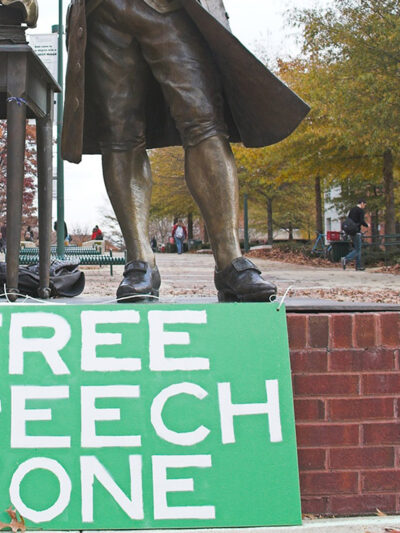 Free speech zone sign in front of statue