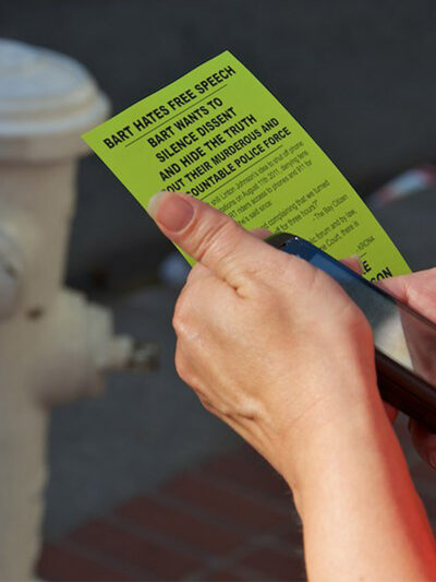 Person holding cell phone and flyer