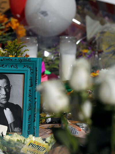 Flowers and a poster with an image of late Associate Justice Ruth Bader Ginsburg are placed outside the Supreme Court in Washington, DC