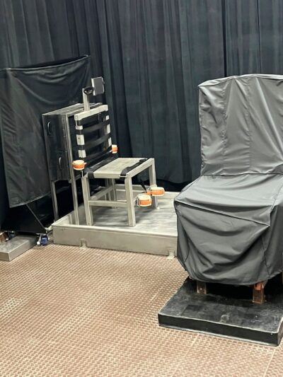 South Carolina's death chamber. A chair in the front is covered in gray cloth. Another chair is metal and has straps attached. The walls are covered by black curtains.