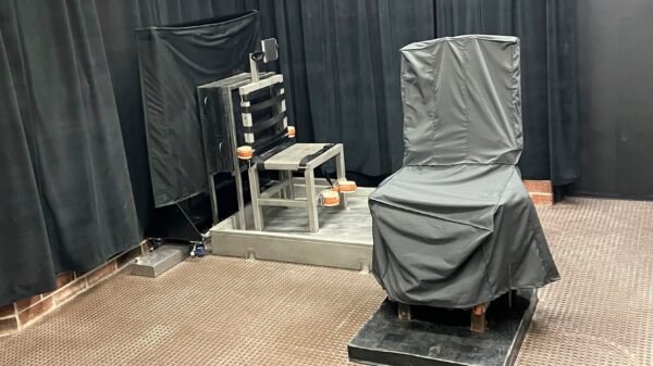 South Carolina's death chamber. A chair in the front is covered in gray cloth. Another chair is metal and has straps attached. The walls are covered by black curtains.