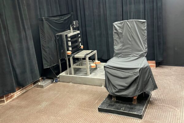 South Carolina's death chamber. A chair in the front is covered in gray cloth. Another chair is metal and has straps attached. The walls are covered by black curtains.