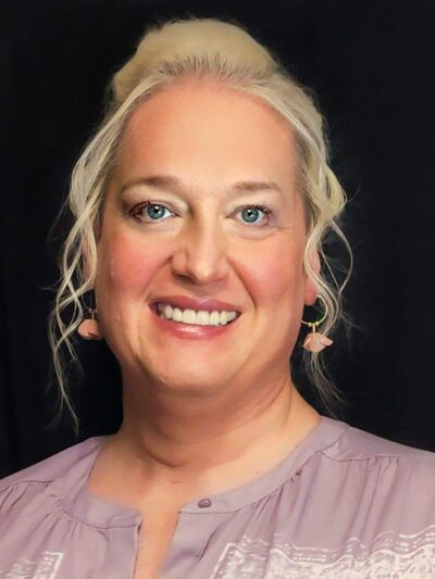 Professional headshot of Alleria Stanley. She has mid-length light-blonde hair and is wearing earrings.