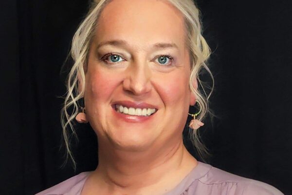 Professional headshot of Alleria Stanley. She has mid-length light-blonde hair and is wearing earrings.