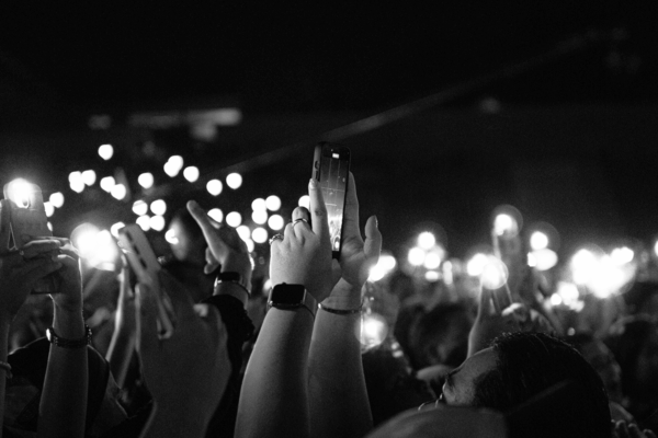 A crowd holds up smartphones with their flashlights on