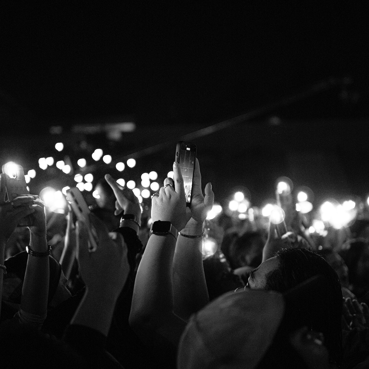 A crowd holds up smartphones with their flashlights on