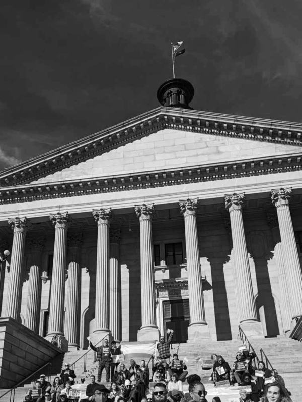 Grayscale photo of people gathered on the State House steps