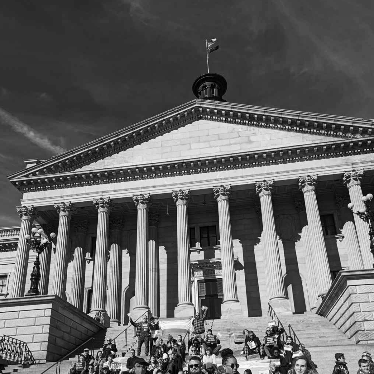 Grayscale photo of people gathered on the State House steps