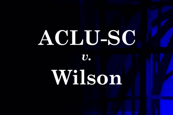 "ACLU-SC v. Wilson." White text on a dark background with shadows of a cage cast by blue and red light.