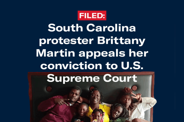 "Filed: South Carolina protester Brittany Martin appeals her conviction to U.S. Supreme Court." Family photo of Ms. Martin, a Black woman with braided hair and a yellow top, seated with her husband and four children."