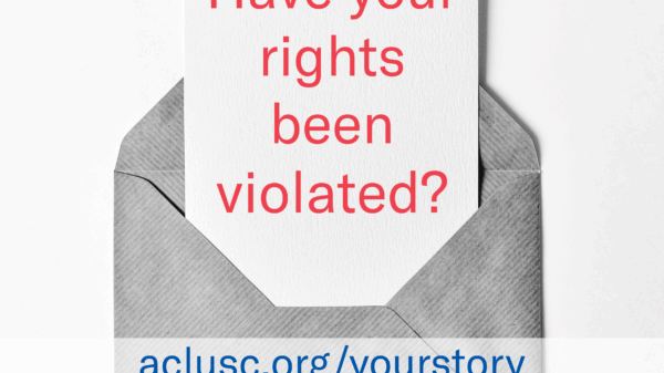 Grayscale photo of a note sticking out of an open envelope containing the words "Have your rights been violated? aclusc.org/yourstory"