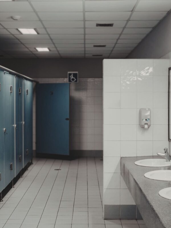 Photo of a public restroom with tile floor and stalls