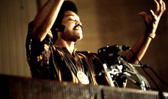 Jackson speaks on a radio broadcast from the headquarters of Operation PUSH (People United to Save Humanity) at its annual convention. July 1973, photograph by John H. White