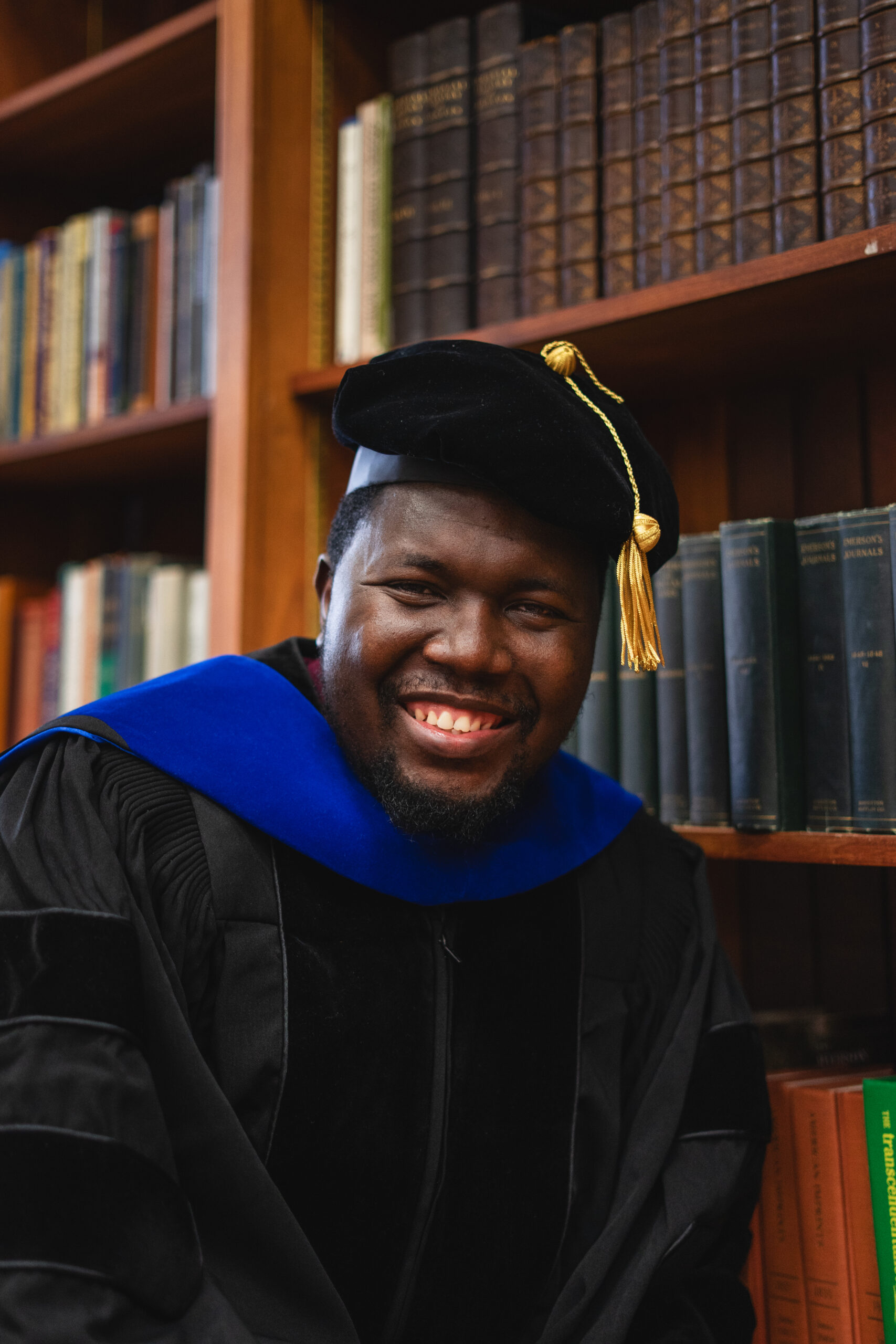Matthew Ariwoola smiling in a cap and gown