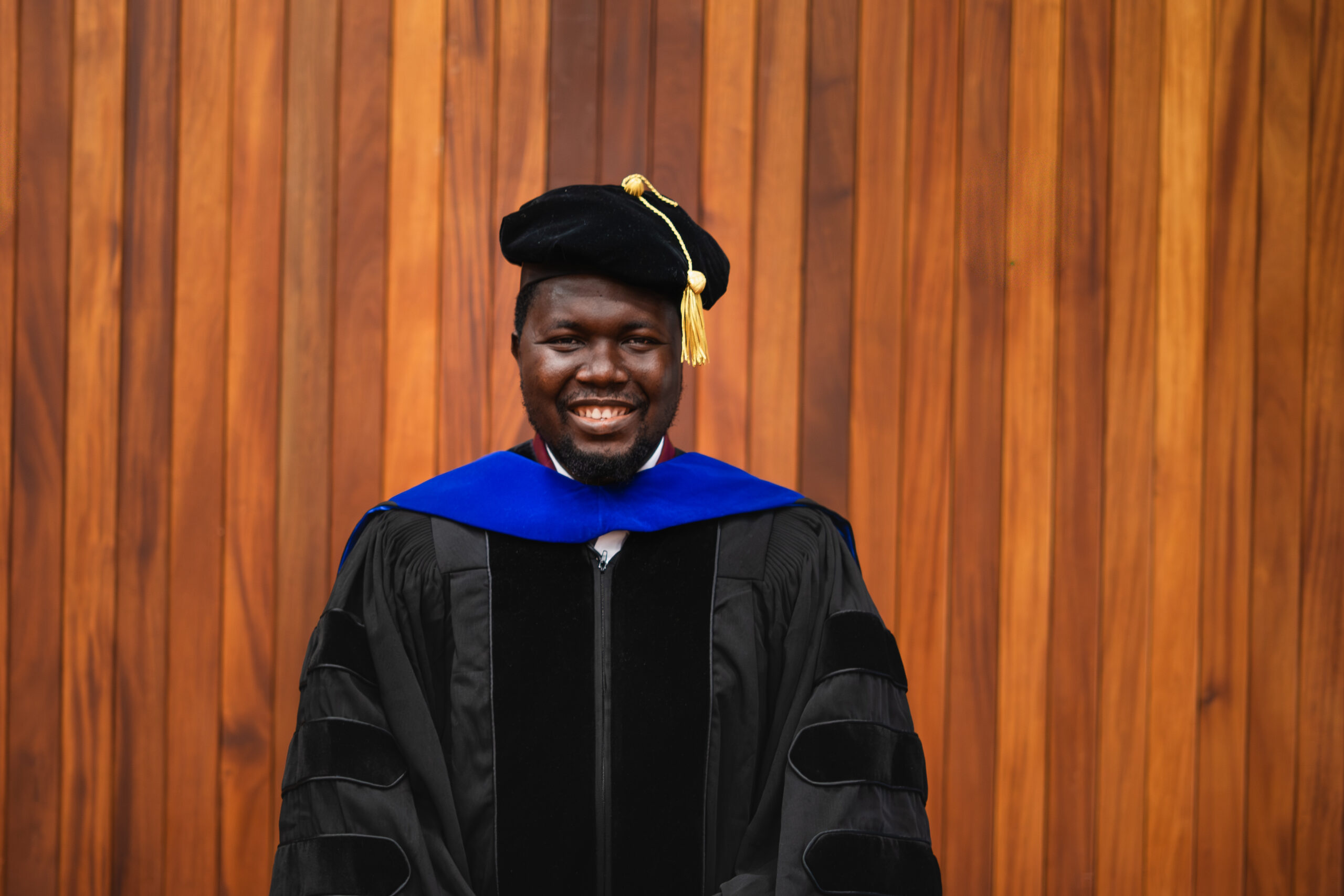 Dr. Matthew Ariwoola in a cap and gown