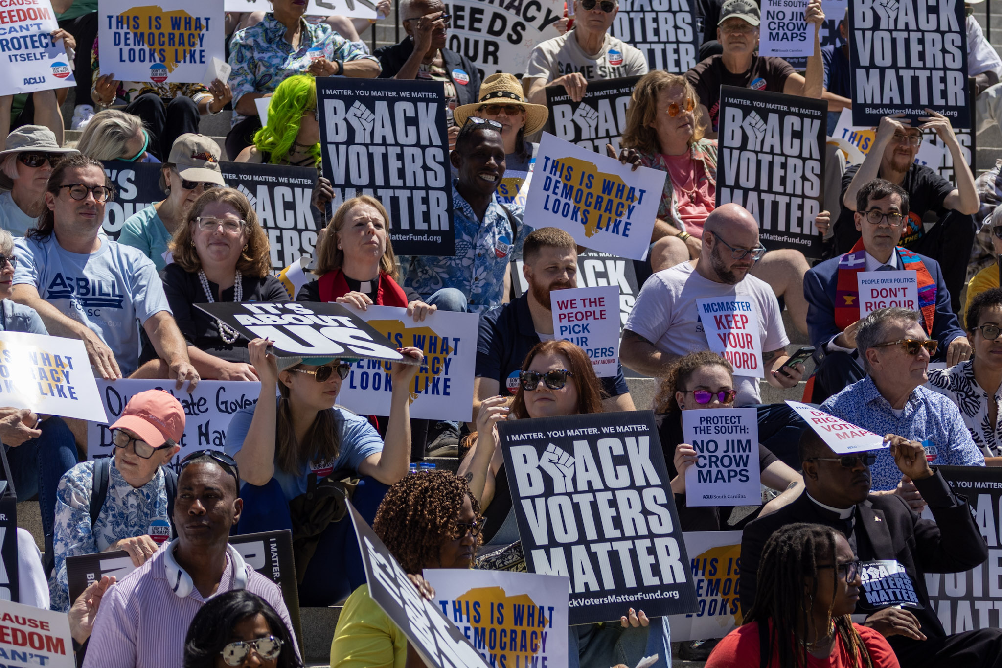 A crowd on the Statehouse steps holding sign that say "Black Voters Matter" and "This is what democracy looks like"