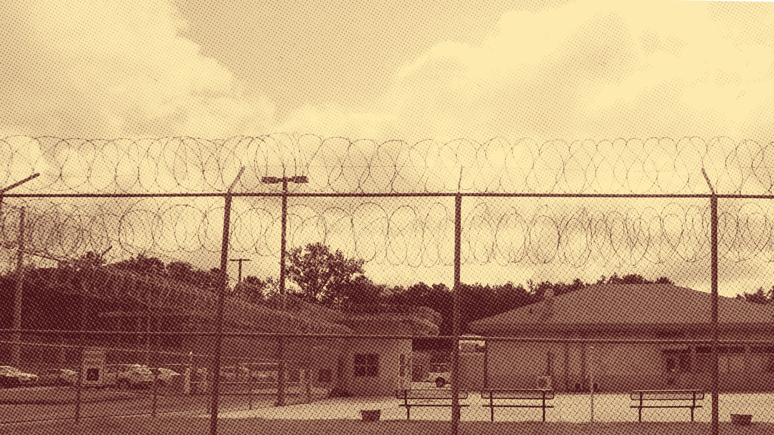 Sepia-toned photo of a juvenile justice facility behind a razor wire fence