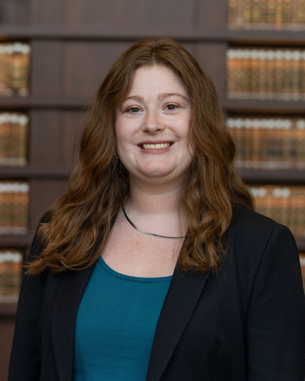 Professional headshot of Cady Barthe, who is smiling and wearing a simple necklace and dark blazer.