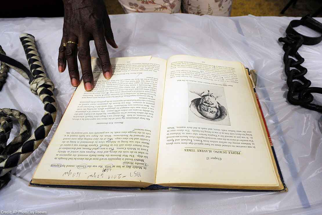 A display on slavery with a whip, book, and shackles