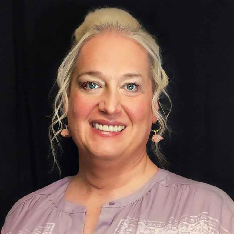 Professional headshot of Alleria Stanley. She has mid-length light-blonde hair and is wearing earrings.