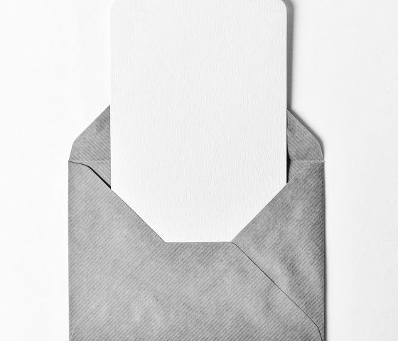 Grayscale photo of a blank note sticking out of an open envelope